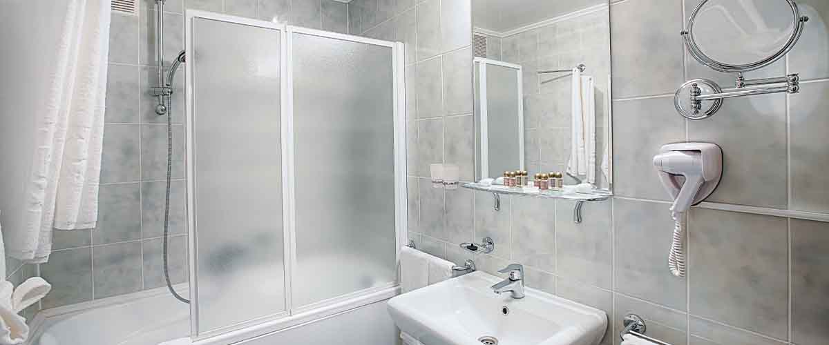 Framed glass shower door installed in small bathroom by Levinson Glass in NYC